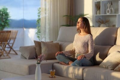 Casual woman breathing fresh air meditating at home