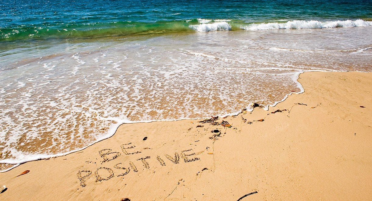 be positive written in the sand on the beach